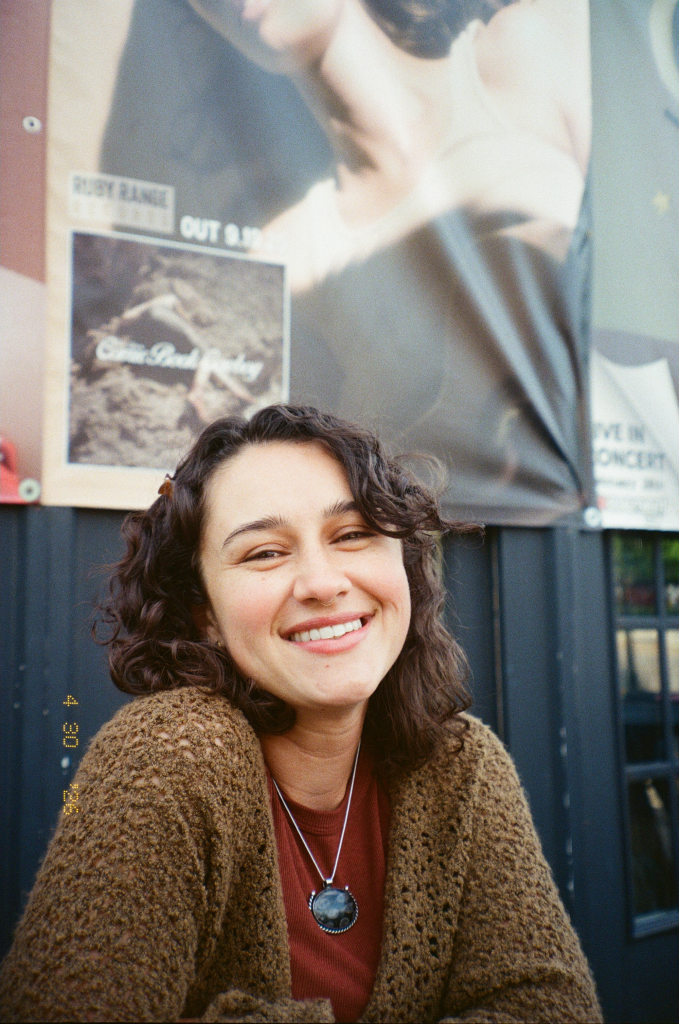 New team member Alyssa headshot sitting in front of a building smiling.